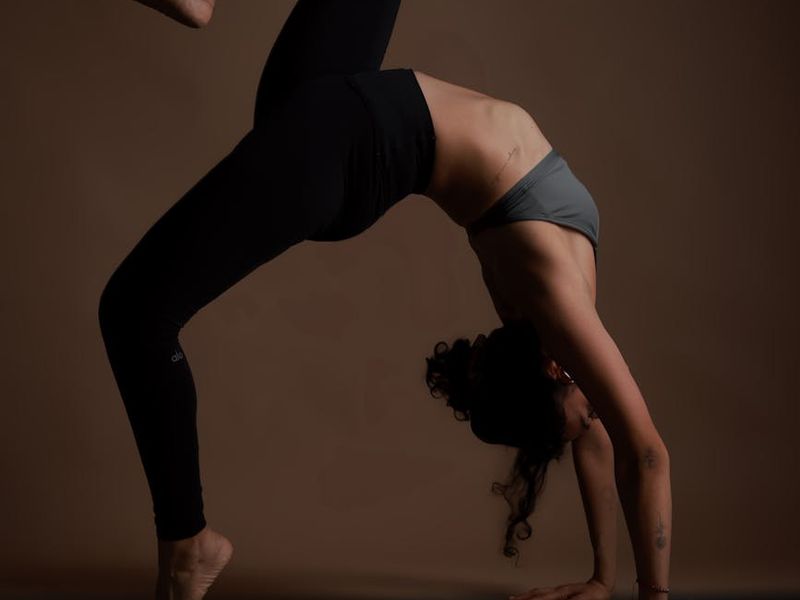 Person practicing yoga in a dark studio with warm amber lighting