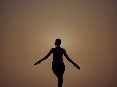 Silhouetted figure moving through a graceful yoga flow